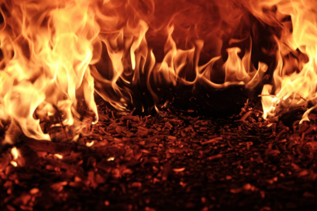 A close-up photo of orange flames burning the ground.